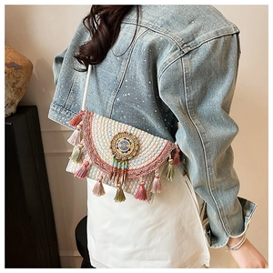 Detail of bohemian woven crossbody bag featuring colorful beads and fringe tassels