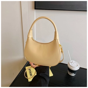 Dettaglio della borsa hobo beige in pelle liscia con elegante cerniera dorata lucida