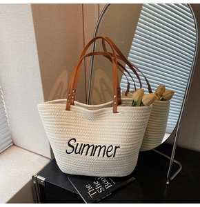 Détail du sac de plage tressé crème avec broderie Summer et poignée en cuir marron