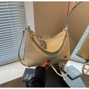 Detail of beige lychee texture leather crescent bag with silver chain and logo embossing