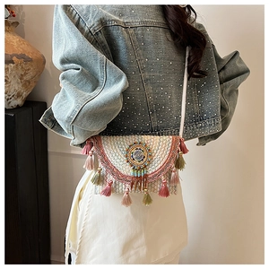 Detailed close-up of ethnic crossbody bag featuring colorful tassels and bead embroidery