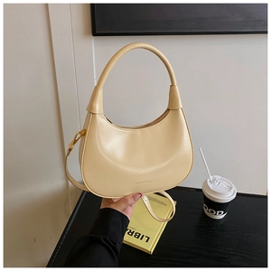 Dettaglio borsa a mezzaluna beige con finiture dorate e tracolla rimovibile
