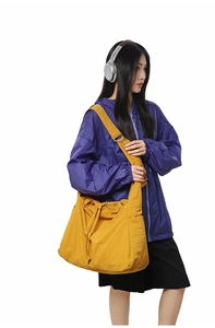 Détail du sac à bandoulière jaune en nylon avec cordon de serrage et grande capacité d'accueil