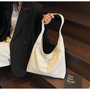 Detail of embroidered 'Enjoy Your Weekend' text on white pleated canvas hobo tote bag
