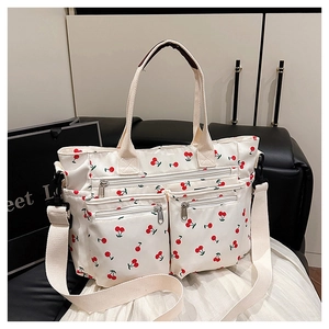 Détail du sac cabas à motif cerise avec deux poches zippées et bandoulières en toile