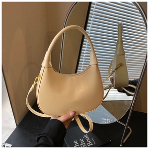 Detail of cream crescent shoulder bag with smooth leather finish and refined hardware