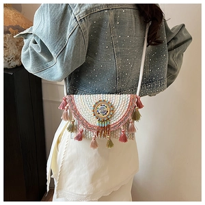 Close-up of bohemian knit crossbody bag featuring colorful tassels and mandala embroidery