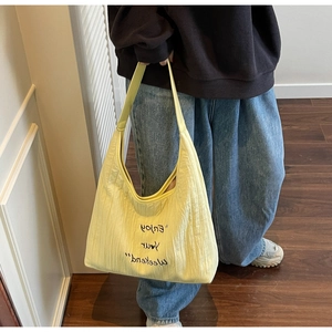 Close-up of yellow canvas tote bag with Enjoy Your Weekend lettering and heart detail