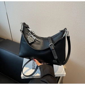 Detail of black pebbled leather half-moon bag with silver butterfly bow and bead charms