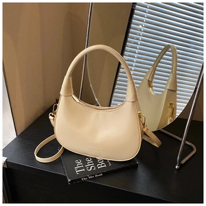 Dettaglio borsa a mezzaluna beige con texture liscia, zip dorata e tracolla regolabile