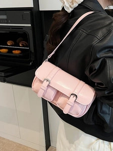 Pink glossy shoulder bag with twin buckles and front pockets worn by model