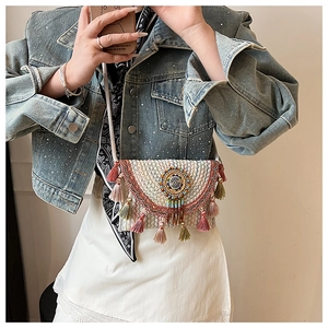 Close-up of bohemian mini crossbody bag with ethnic embroidery and colorful tassels