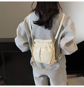 Fashionable beige quilted drawstring backpack with elegant golden metal chain straps