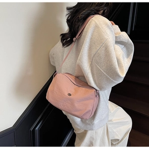 Sac bandoulière rose minimaliste avec sangle réglable et logo métallique élégant