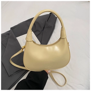 Dettaglio della borsa hobo beige con logo dorato su blazer grigio per stile chic