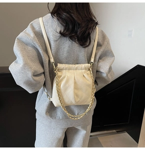 Vue détaillée du dos d'un sac à dos matelassé blanc crème avec cordon et chaîne dorée