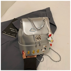 Details des silbernen Metallic-Rucksacks mit Entenstickerei und Drehverschluss