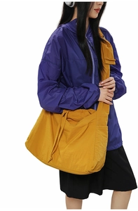 Détail du sac bandoulière jaune en nylon avec cordon et poche sur la sangle large