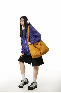 Détail du sac à cordon en nylon jaune avec bandoulière sur un mannequin style urbain