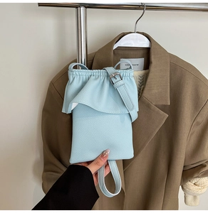 Détail du mini sac seau bleu ciel avec bordure à volants et boucle en métal argenté