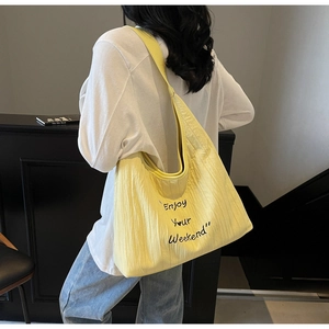 Macro shot of large bright yellow canvas tote bag with Enjoy Your Weekend print