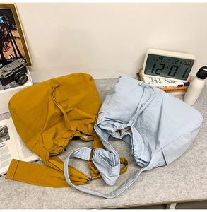 Détail de sacs à bandoulière avec cordon en jaune moutarde et bleu clair avec sangles