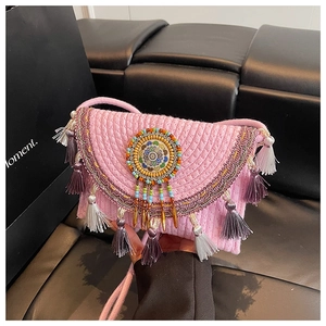 Detail of pink knitted shoulder bag with beaded mandala and colorful tassels