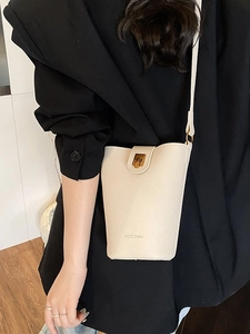 Minimalist beige lychee leather bucket bag with gold hardware and shoulder strap