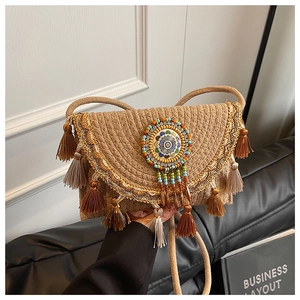 Detail of bohemian woven bag with ethnic badge and colorful fringe tassels