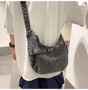 Detail view of denim hobo bag with grey snowflake wash and woven rope decoration