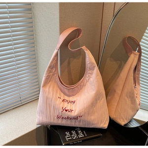 Detail of light pink tote bag with Enjoy Your Weekend embroidery and wide shoulder strap