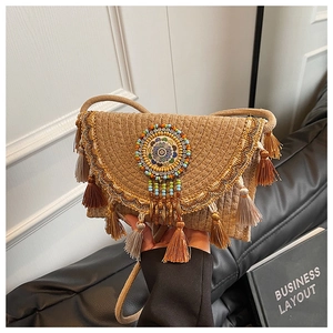 Detail of bohemian knit bag featuring colorful bead embroidery and decorative tassels