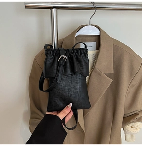 Détail du mini sac seau en cuir noir grainé avec cordon de serrage et volants