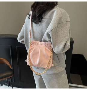 Vue arrière d'un mannequin portant un sac bandoulière rose matelassé avec chaîne