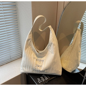Detailed shot of beige pleated canvas tote bag with Enjoy Your Weekend blue embroidery