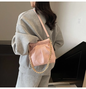 Detail of pink quilted shoulder bag with chain strap and pleated bucket design