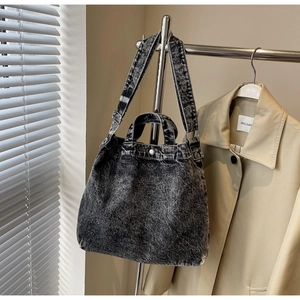 Detail of acid wash denim tote bag with sturdy handles and adjustable shoulder strap