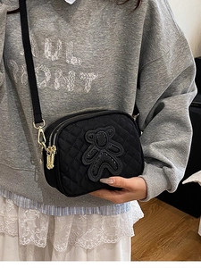 Chic black quilted crossbody bag with sequin bear patch and gold multi-zipper detail