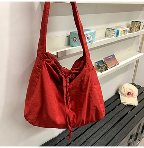 Détail du sac en toile rouge à cordon avec grande capacité et large bandoulière