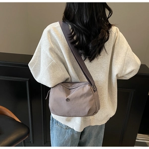 Détail du sac à bandoulière rose-gris avec une large sangle réglable en tissu confortable