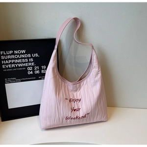 Detail of light pink pleated tote bag with Enjoy Your Weekend embroidery text
