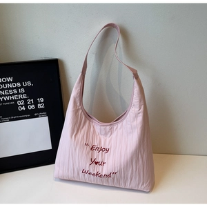 Detail of pink hobo tote featuring Enjoy Your Weekend embroidery and pleated texture