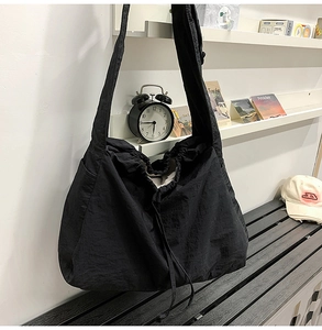 Détail du sac à cordon en nylon noir avec texture imperméable et bandoulière large