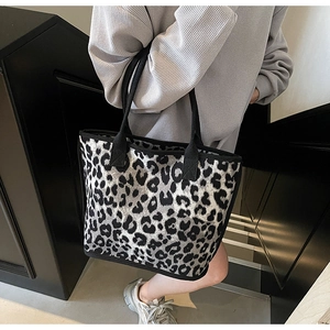 Close-up of leopard print large tote bag with wide black strap on a shoulder