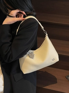 Creamy white pebbled leather hobo shoulder bag with a beaded grape charm and silver logo