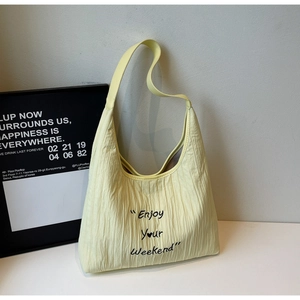 Detail of light yellow pleated canvas tote bag with Enjoy Your Weekend artistic embroidery