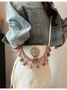 Bohemian knit crossbody bag with colorful tassels and ethnic beaded embroidery detail