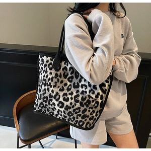 Detail view of large leopard print tote bag with thick black woven shoulder straps