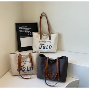 Three minimalist canvas tote bags in cream brown and grey with leather shoulder straps