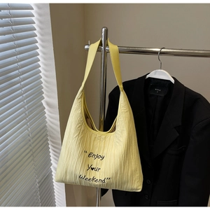 Close-up of yellow pleated canvas tote bag with Enjoy Your Weekend slogan print